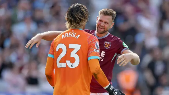 Alphonse Areola of West Ham United is embraced by teammate Niclas Fullkrug