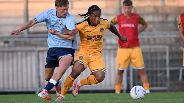 Moses Alexander-Walker dribbles the ball for Newport County against Newport City
