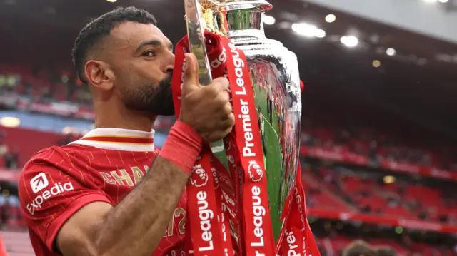Mohamed Salah kisses the Premier League trophy