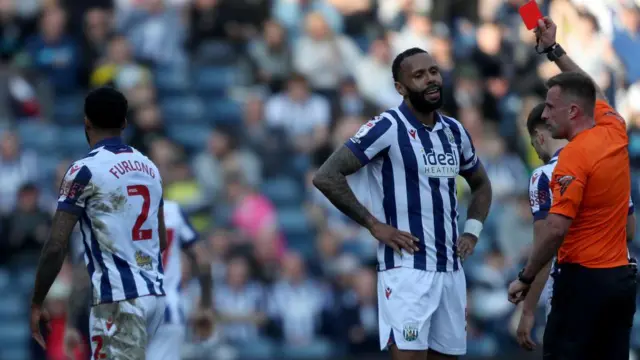 West Bromwich Albion defender Darnell Furlong [left] walks off the pitch after being shown a straight red card against Queens Park Rangers