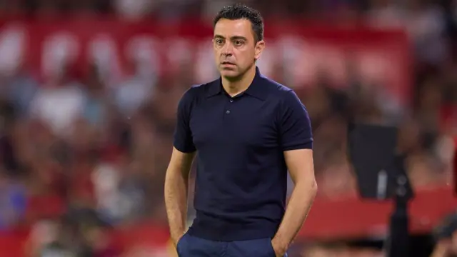 Xavi looks on from the touchline