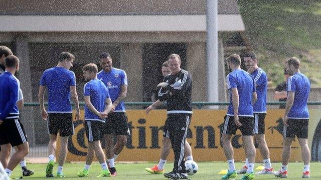 Northern Ireland players dodge a sprinkler during training in France