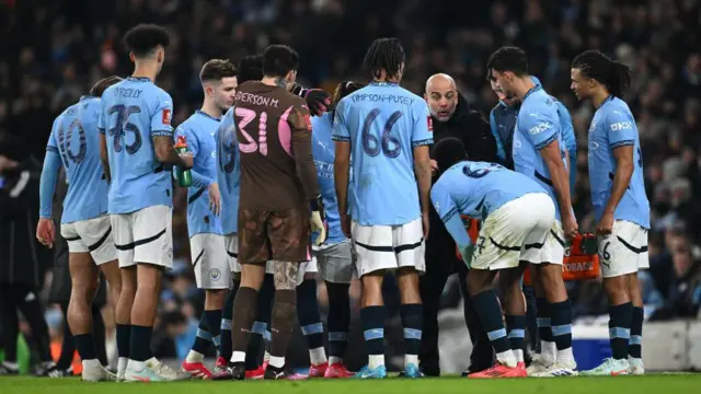 Pep Guardiola giving a team talk to his players