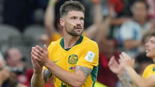 Cameron Burgess applauds at the end of Australia's victory
