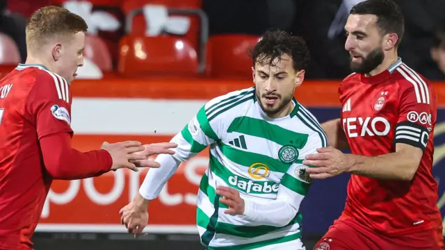 Celtic's Nicolas Kuhn (C) and Aberdeen's Gavin Molloy (L) and Graeme Shinnie in action during a William Hill Premiership match between Aberdeen and Celtic at Pittodrie Stadium