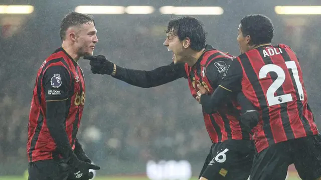 Enes Unal celebrates a goal in the rain with his fellow Bournemouth players