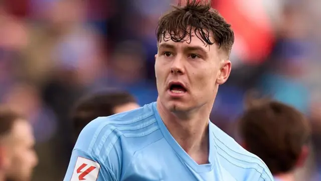 Jorgen Strand Larsen celebrates a goal by pulling at the badge on his light blue Celta Vigo shirt