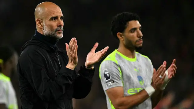 Pep Guardiola applauds the Manchester City fans while looking disappointed