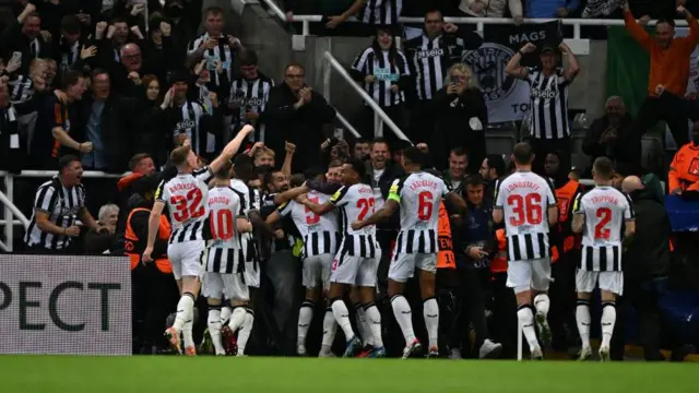 Newcastle players celebrate against PSG 