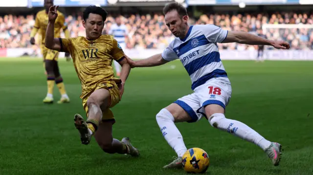 QPR's Rhys Norrington-Davies (R) takes on Ryoya Morishita of Blackburn