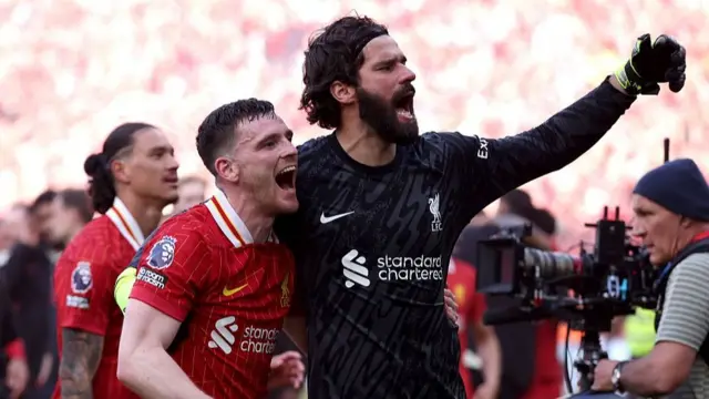 Andy Robertson and Alisson celebrating in front of the Kop at Anfield