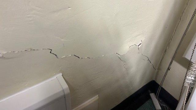 A crack runs down an inside wall towards a corner