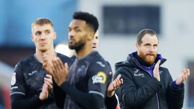 Swansea players and staff clap their fans after defeat at Stoke 