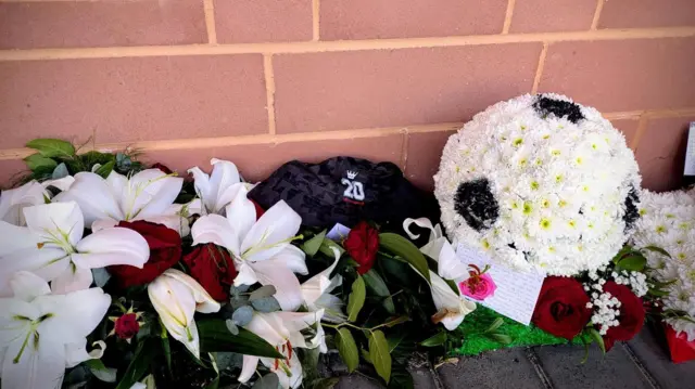 White flower garlands laid next to a red brick wall
