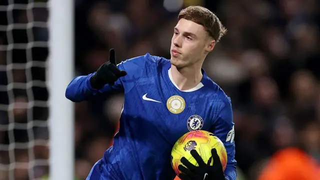 Cole Palmer waves his finger in celebration while holding the ball with his other hand after scoring for Chelsea against Bournemouth