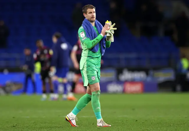 Goalkeeper Alex Smithies, wearing an all-green kit, applauds fans (out of picture) after playing for Cardiff City