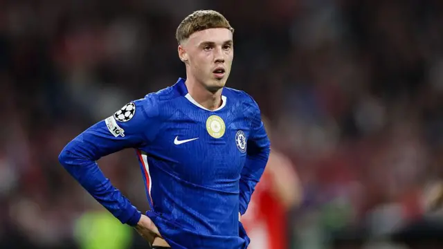 Cole Palmer stands still with his hands on his hips