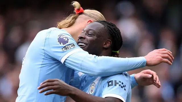 Erling Haaland hugs Jeremy Doku