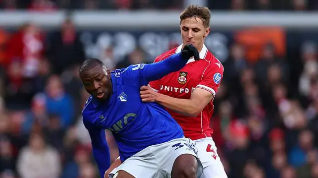 Edo Kayembe of Watford is challenged by Max Cleworth of Wrexham earlier this season 