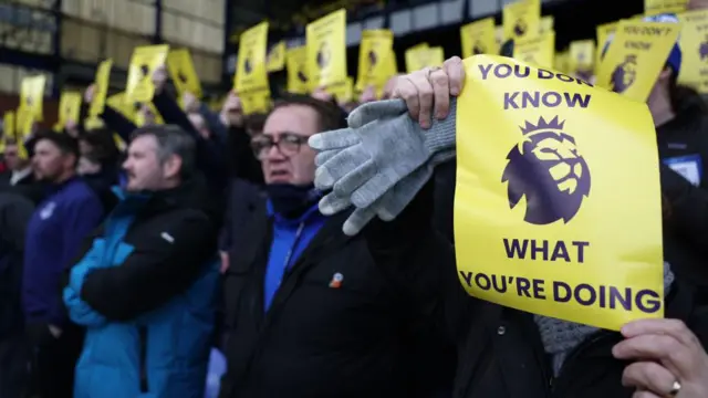 A general view of Everton fans holding banners reading 'you don't know what you're doing'