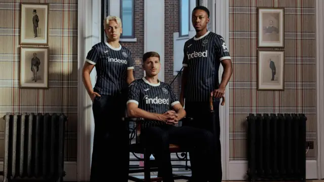 Vitaly Janelt, Antoni Milambo and Wiktoria Kiszkis wearing the new Brentford away kit for the 2026-2027 season 