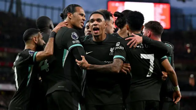 Liverpool team-mates celebrating after scoring a goal against Arsenal