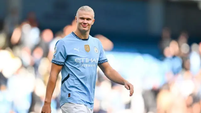 Erling Haaland smiling as he walks