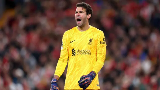 Alisson shouts during match