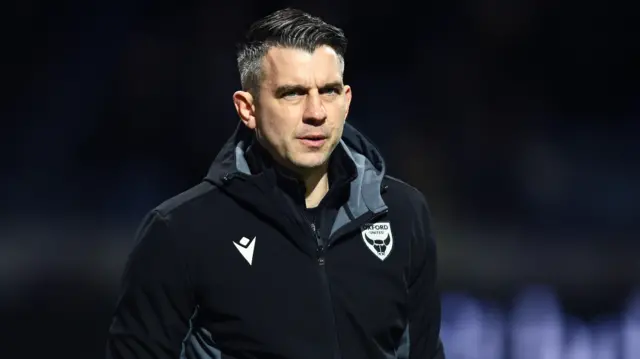 Oxford boss Matt Bloomfield on the touchline wearing a black training top with the Oxford club badge on it