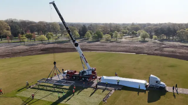 A crane lifts out pitches from Eisenhower Park in New York on to a truck