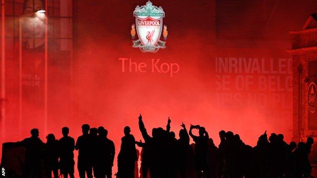 Liverpool fans celebrate outside Anfield as their team lift the Premier League trophy