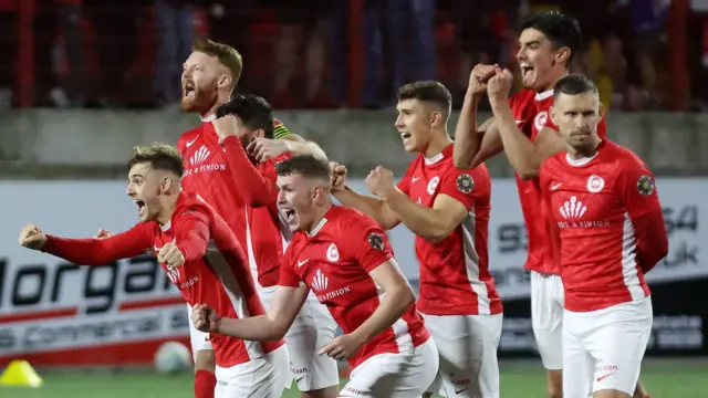 Larne players celebrate beating Ballkani on penalties 