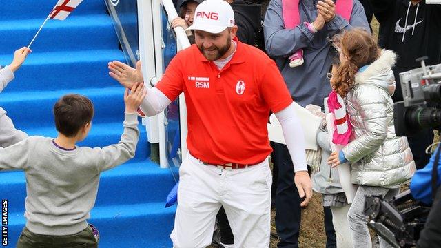 Andy Sullivan high fives a young fan at the first tee