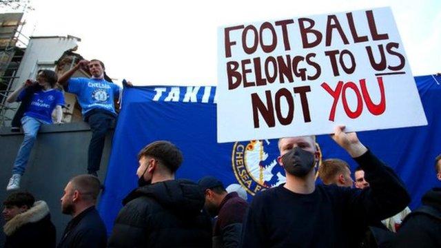 Fans with signs protesting