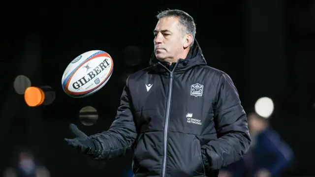 Franco Smith tosses a rugby ball in the air before Glasgow's URC match against Munster