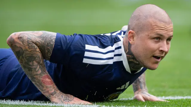 A close-up of Lyndon Dykes, wearing his blue Scotland kit, lying down on his front on the pitch during their game against Curacao on 30 May