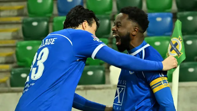 Bigirimana celebrates with Danny Wallace following Dungannon Swifts' win on penalties