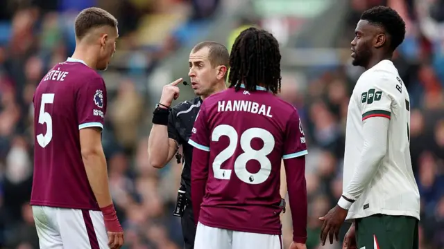 Referee Peter Bankes interacts with Maxime Esteve of Burnley 