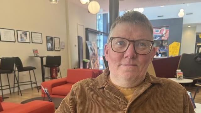 A man sat inside the Phoenix Cinema foyer