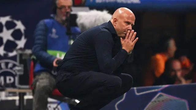 Arne Slot hunches on the touchline