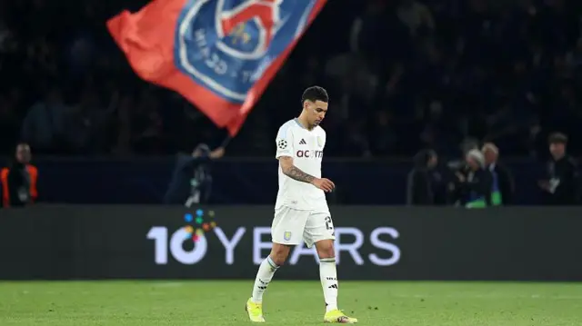 Morgan Rodgers walks dejectedly in front of PSG flag