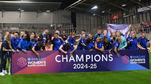 Chelsea players stand behind a board reading Champions 2024-25