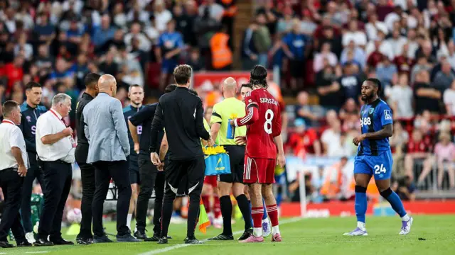Referee Anthony Taylor stops game and speaks to Arne Slot and Andoni Iraola after Antoine Semenyo of Bournemouth received racist abuse