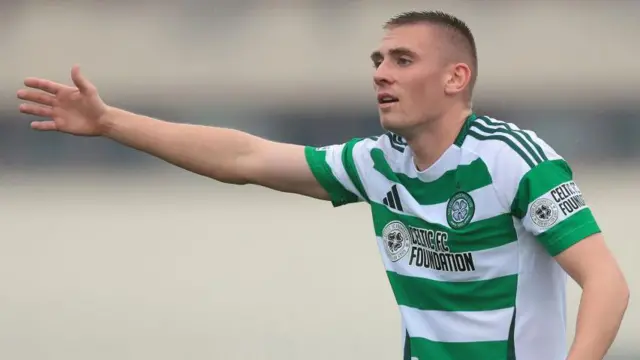 Kyle Ure puts is arm out offering some instructions to team-mates during a game for Celtic 