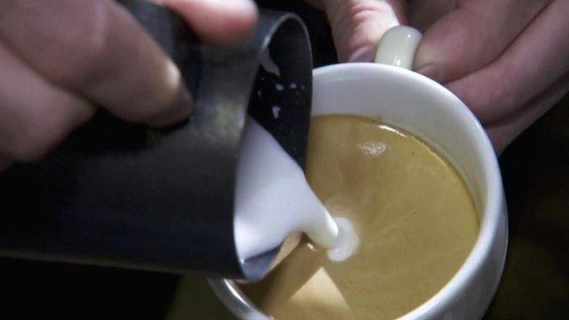 Milk being poured into coffee