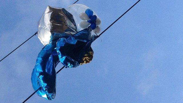 Helium balloons tangled in overhead railway power cables