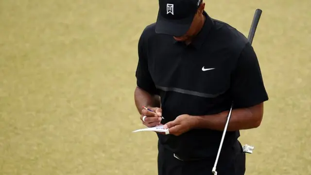 Tiger Woods records his score
