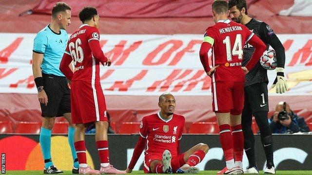 Liverpool defender Fabinho sits on the pitch after sustaining an injury during the Champions League group game with Midtjylland