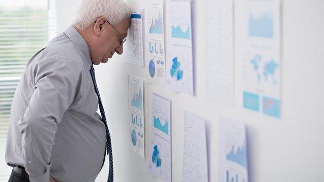 Businessman overwhelmed by spreadsheets