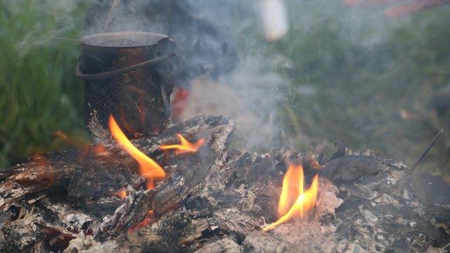 A family from Damascus heat a small pot of water to make coffee